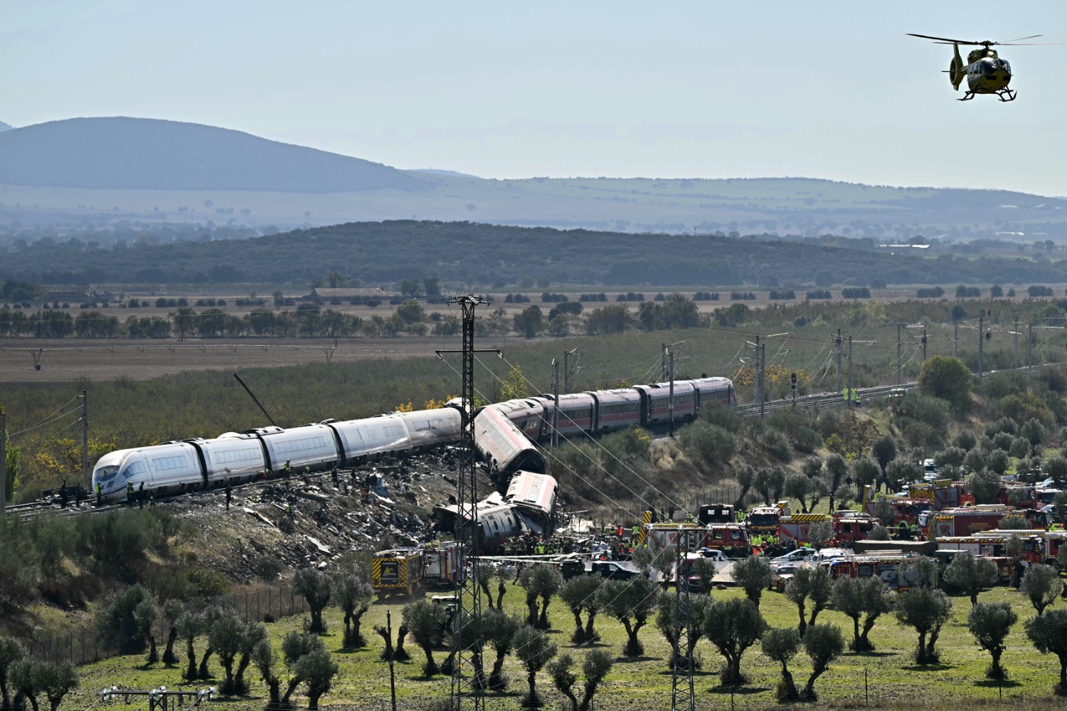Foto por JAVIER SORIANO / AFP. Los servicios de emergencia trabajan en el lugar del choque entre dos trenes de alta velocidad, un tren AVE de Renfe y un tren de Iryo, a unos 150 km al sur de Madrid entre Urda y Los Yébenes, en la provincia de Toledo, el 28 de octubre de 2026. Una colisión de trenes de alta velocidad al sur de Madrid causó hoy la muerte de 68 personas y dejó decenas de heridos, y la cifra de víctimas podría aumentar, según las autoridades, en el segundo desastre de este tipo en España este año.